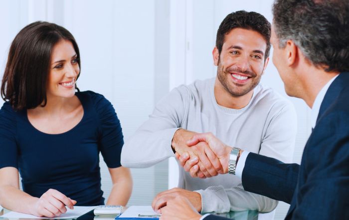 Couple and mortgage advisor discussing Does Your Credit Score Impact Your Mortgage Rate?