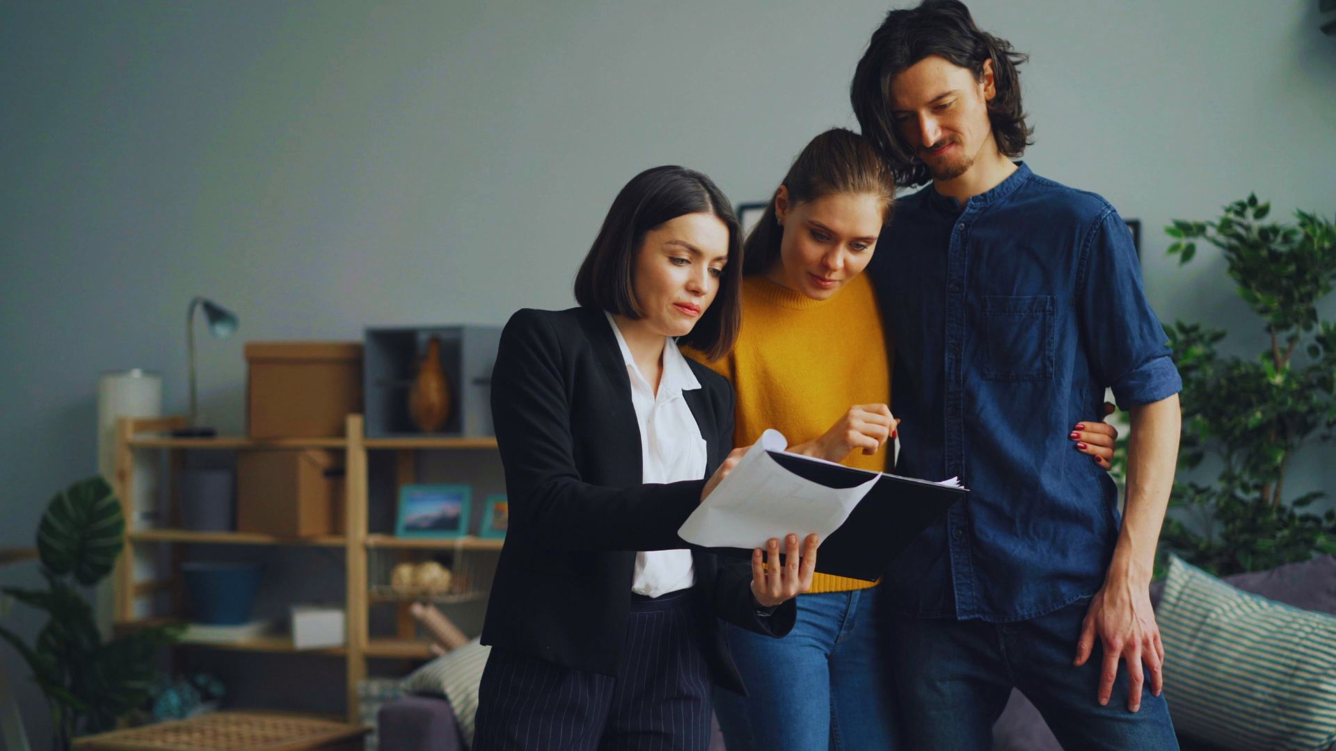 Homebuyer signing real estate closing documents with a lawyer reviewing contract details.